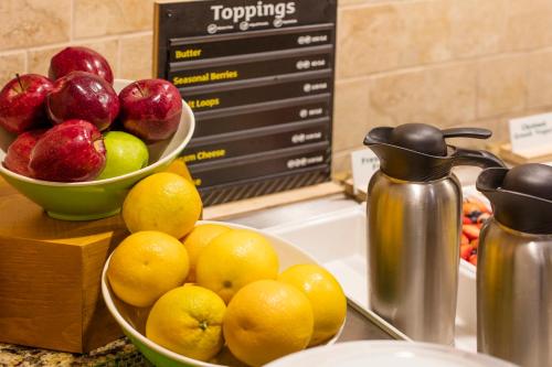 um balcão com duas tigelas de maçãs e laranjas em Holiday Inn Austin Midtown by IHG em Austin