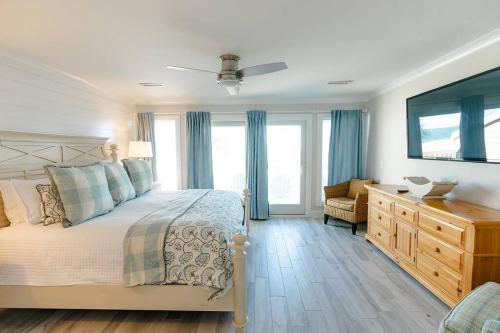 1 dormitorio con 1 cama, vestidor y ventanas en Beach Club Villa 32 - Newly Renovated! Direct Oceanfront, en Isle of Palms