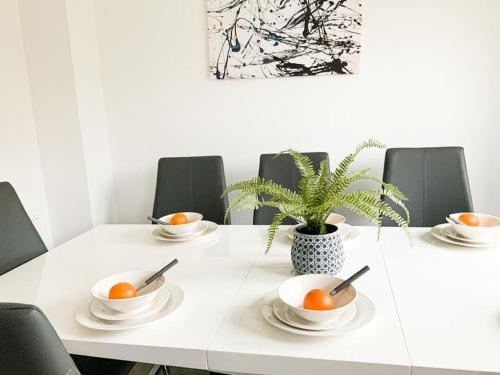 un tavolo bianco con ciotole di arance e una pianta di Antley House ad Andover