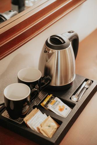a tray with two coffee cups and a tea kettle at 1909 Guesthouse in Kalavrita