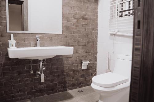 a bathroom with a white sink and a toilet at Bricks Point - Boutique Apartments in Abuja