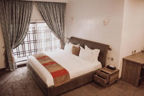 a bedroom with a large bed and a large window at Bricks Point - Boutique Apartments in Abuja