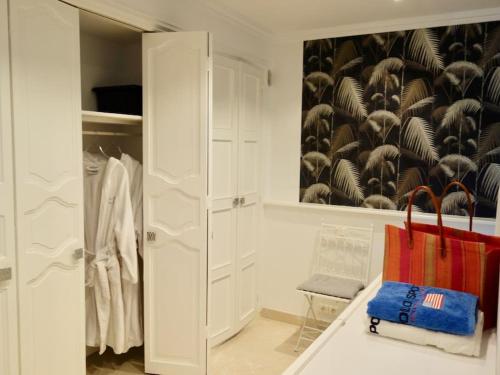 un armario con armarios blancos y una pintura de aves en Elégant-Cosy 2P55M2 dans bas de villa provençale !, en Villeneuve-Loubet