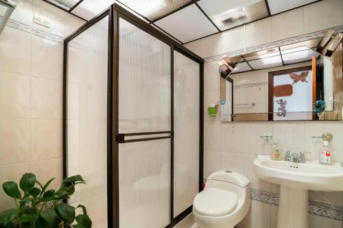 a bathroom with a shower and a toilet and a sink at Excelente cómoda habitación privada cerca parque Simon Bolivar in Bogotá