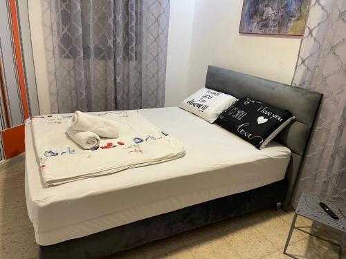 a small bed with white sheets and pillows on it at רויאל פארק1 in Eilat
