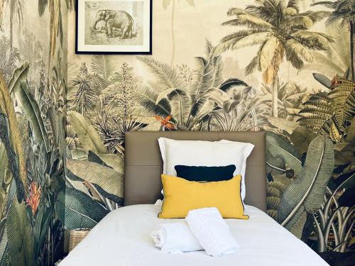 une chambre avec un lit avec un papier peint tropical dans l'établissement Leonardo lovely flat 2 rooms with AC, à Annecy