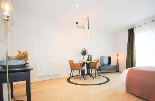 une chambre avec un lit, une table et un piano dans l'établissement Nid du lac 200 m du lac, à Annecy
