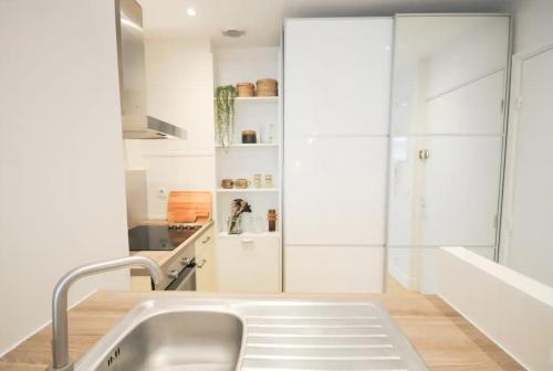 a kitchen with white cabinets and a sink at Nid du lac 200 m du lac in Annecy