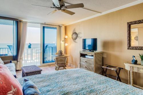 デイトナビーチにあるHarbour Beach Resortのベッドルーム(ベッド1台、テレビ、バルコニー付)