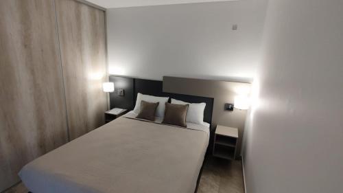 Orfila Apart 5 في ميندوزا: غرفة نوم بسرير ابيض كبير ومصباحين