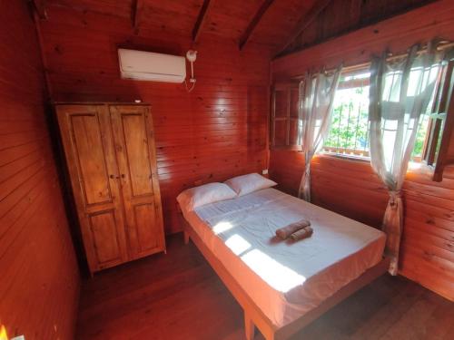 een slaapkamer met een bed in een houten kamer bij A la Vera del Río in Puerto Iguazú