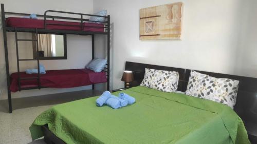 a bedroom with a green bed with a blue teddy bear on it at San Salvatore Home in St. Julianʼs