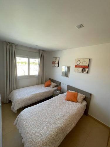 a bedroom with two beds and a window at Condado de Alhama Murcia in Alhama de Murcia