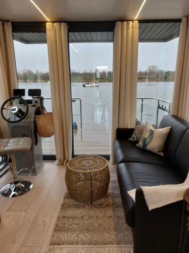 a living room with a couch and a large window at Lemuria Houseboat - pływający domek na wodzie in Wrocław