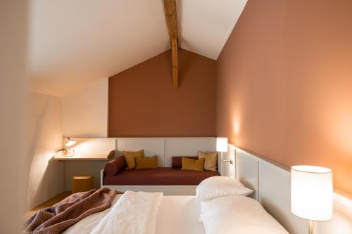 a bedroom with a bed and a couch at Leuchtenburg am See in Caldaro