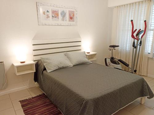 1 dormitorio con 1 cama y 2 luces en 2 mesas en Casa de los Loles Tandil, en Tandil