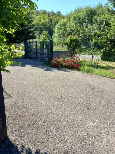 un vialetto con cancello e fiori in un parco di residence emile a Meyras