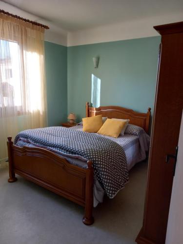 a bedroom with a bed with yellow pillows and a window at residence emile in Meyras