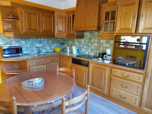 a kitchen with wooden cabinets and a table in it at residence emile in Meyras