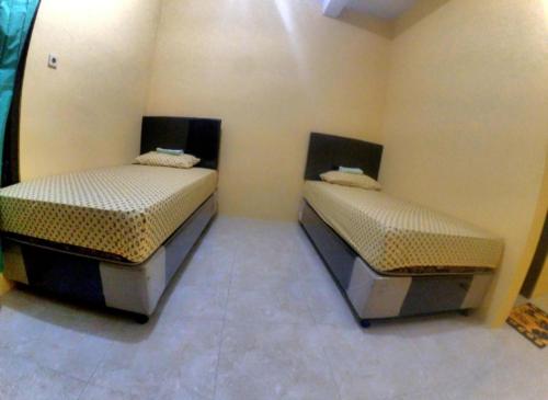 Ένα ή περισσότερα κρεβάτια σε δωμάτιο στο Nitha Homestay