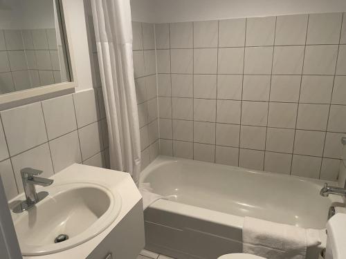 La salle de bains est pourvue d'une baignoire, d'un lavabo et de toilettes. dans l'établissement Hotel Motel Le Regent, à Québec