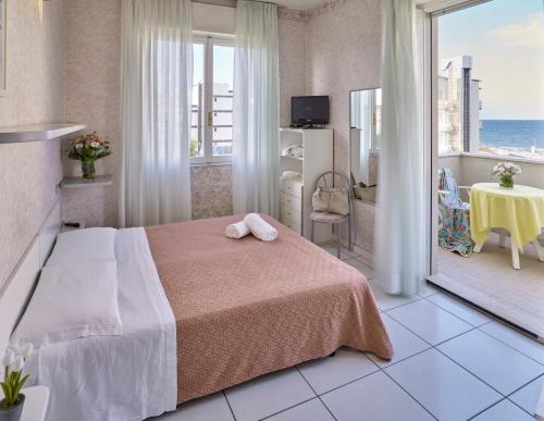 a bedroom with a bed and a view of the ocean at Marittima Rooms in Milano Marittima