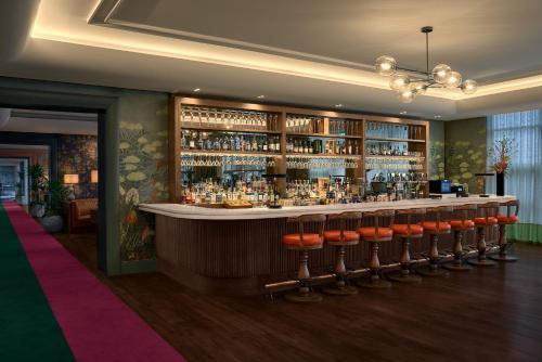 a bar with a row of stools in a room at The g Hotel in Galway