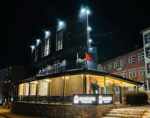 un edificio con luces por la noche en GRAND JNK Boutique Hotel, en Kukës