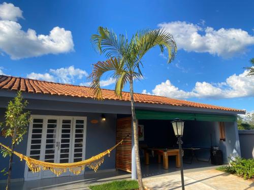 a palm tree in front of a house at Pousada Vila Tadeu in São João Batista do Glória