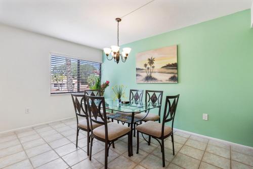 uma sala de jantar com uma mesa de vidro e cadeiras em Midnight Cove 6327 #725 em Sarasota