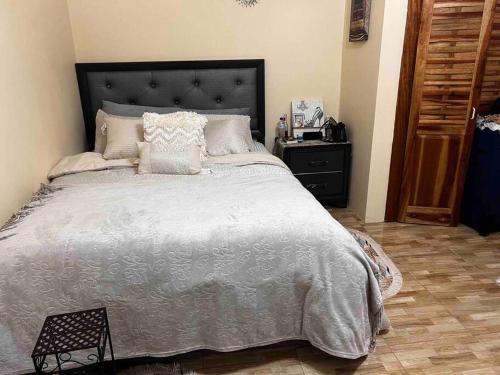1 dormitorio con 1 cama grande y cabecero negro en Cheerful VinAdas, en Mandeville