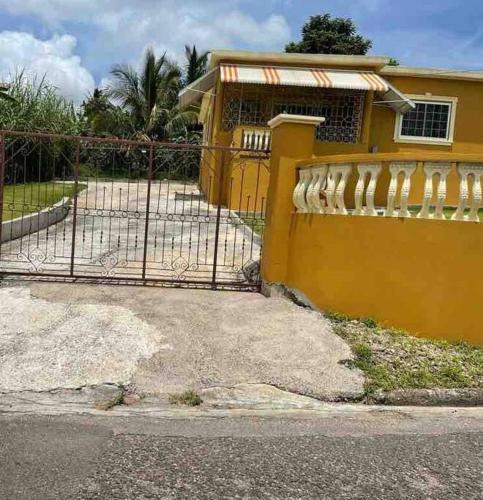 a yellow fence in front of a house at Cheerful VinAdas in Mandeville