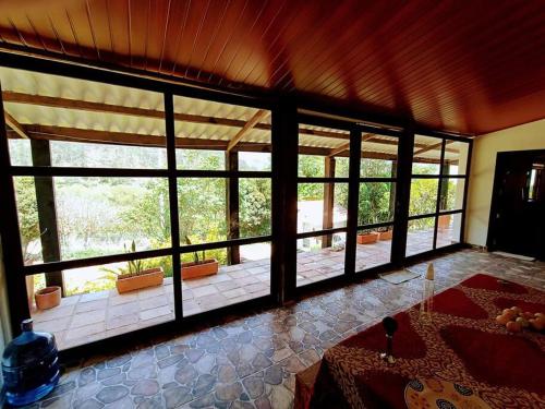une grande chambre avec de grandes fenêtres dans une maison dans l'établissement Finca de descanso Amai Haru Jenesano, à Jenesano