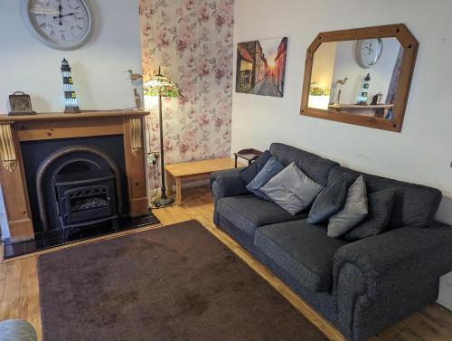 a living room with a couch and a fireplace at Endeavour Cottage Whitby sleeps 6 in Whitby