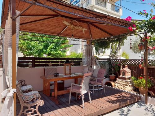 a wooden pergola with a table and chairs on a deck at Villa Arktos in Nydri