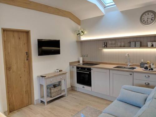 a kitchen with a sink and a stove top oven at BARLEY - cosy stylish apartment - easy access to Bath and many nearby attractions in Box