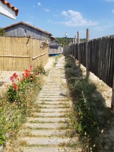 a fence and a path with flowers on it at Guesthouse Évasion in Contis-les-Bains