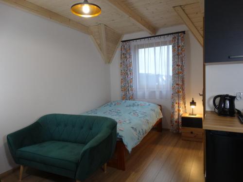 コシチェリスコにあるApartamenty Tatrzańska Dolinaのベッドルーム(緑のソファ、ベッド付)
