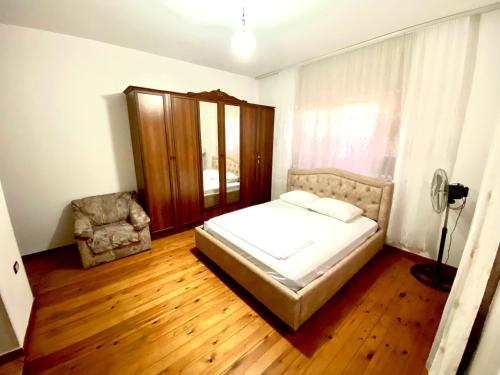 a bedroom with a bed and a chair in it at Villa Osmani in Durrës