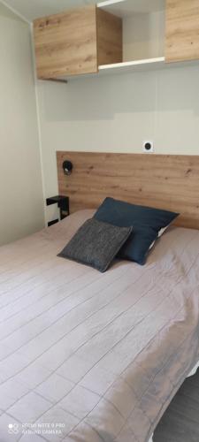une chambre avec un grand lit avec une tête de lit en bois dans l'établissement Baia 1, à Drammont