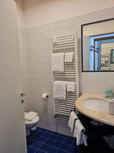 W łazience znajduje się umywalka, toaleta i lustro. w obiekcie Casa Pianta w Cavallino-Treporti