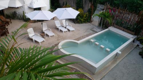 an overhead view of a swimming pool with chairs and umbrellas at Arte Sano Hotel Only Adults - Near Beach in Holbox Island
