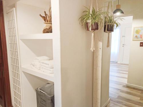 baño con estanterías blancas y macetas en Casa de los Loles Tandil, en Tandil