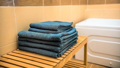 a stack of blue towels sitting on a rack in a bathroom at Apartament Mamaia Nord in Mamaia Nord