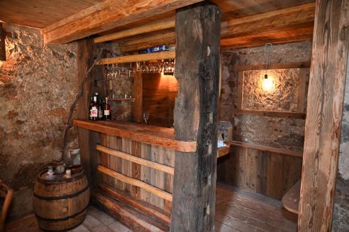 a bar in a wooden cabin with a barrel at Etno House Gosteče- Suite with Finnish sauna in Mozirje