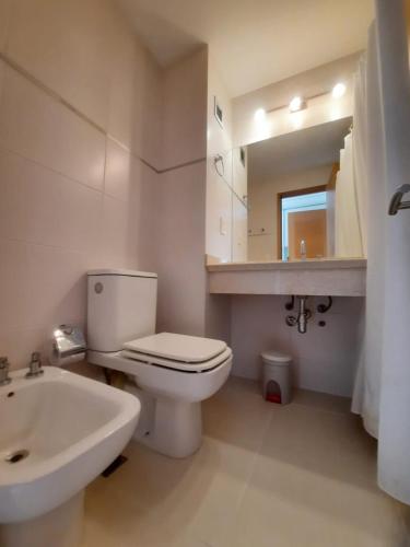 a bathroom with a toilet and a sink and a mirror at Lujoso apartamento en la Mansa in Punta del Este