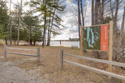 a sign on a fence next to a lake at Clam Lake Vacation Rental with Deck and Shared Dock! in Bellaire