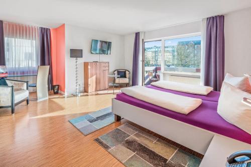 a bedroom with two beds and a large window at Hotel Am Gottesauer Schloss in Karlsruhe