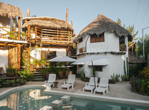 un complexe avec une piscine, des chaises et un bâtiment dans l'établissement Arte Sano Hotel - Adults only, à Holbox