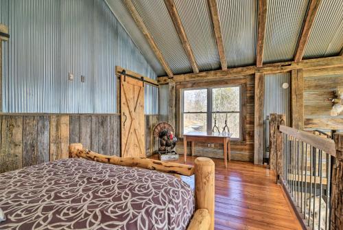a bedroom with a bed in a room with wooden walls at Lakefront Lewisburg Vacation Rental with Deck! in Lewisburg